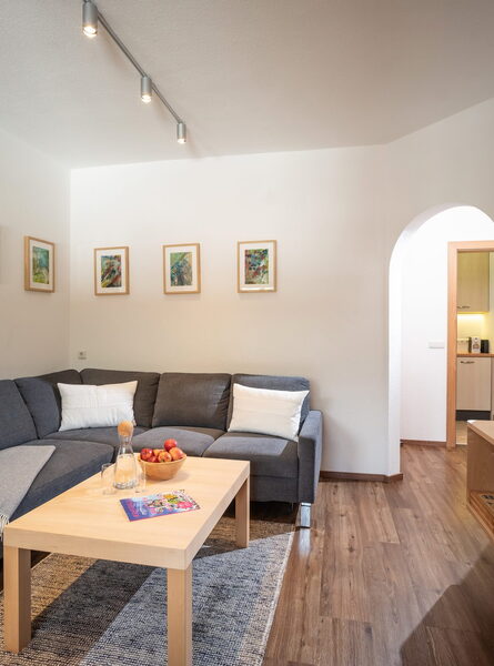 Gemütliches Wohnzimmer mit großem Sofa und Flachbild-TV