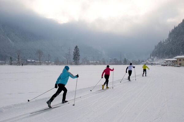 Cross-country skiers on a wide trail in the Zillertal valley