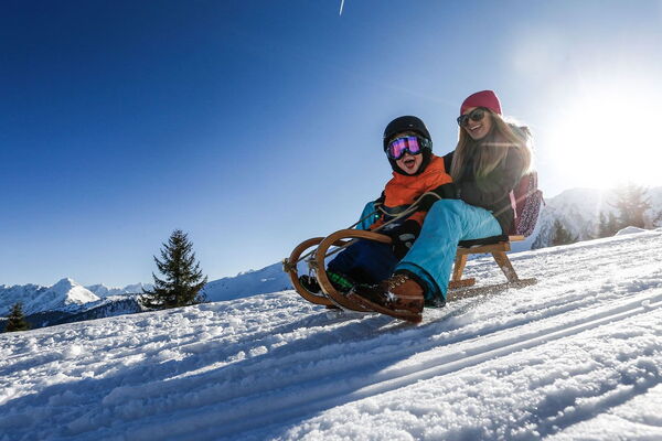 Two people tobogganing in the Zillertal valley