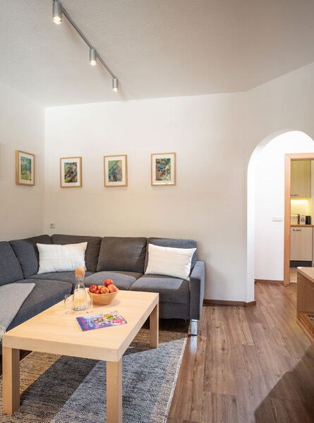 Wohnzimmer von Moni’s Apartment mit Sofa und Fernseher