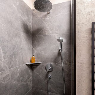 Begehbare Regendusche und Handtuchheizung im Badezimmer