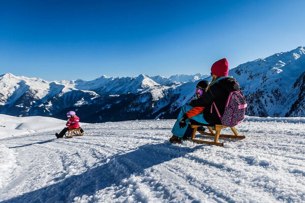 Family tobogganing with views of the Zillertal Alps