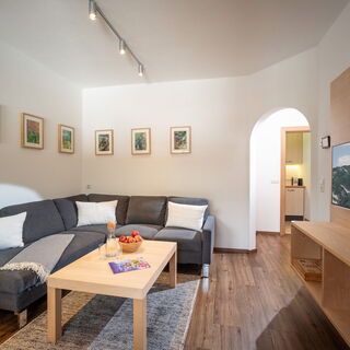 Gemütliches Wohnzimmer mit großem Sofa und Flachbild-TV
