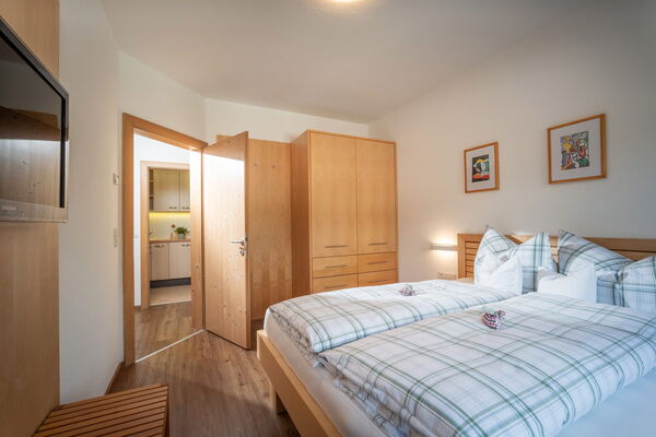 Helles Schlafzimmer mit Doppelbett, Stauraum und Flachbild-TV